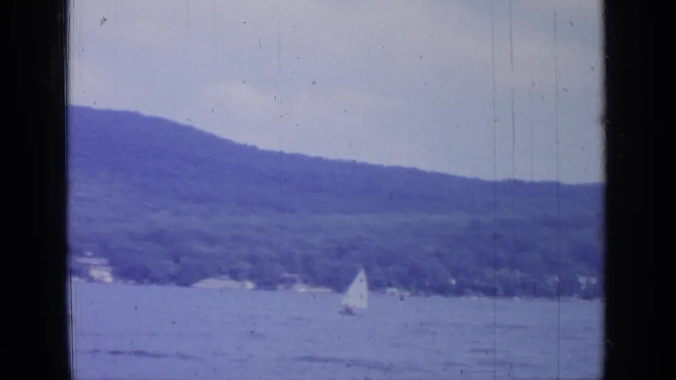 Greenwood Lake sailboat scene from 1964, filmed from a moving boat with soft focus and visible 8mm texture.