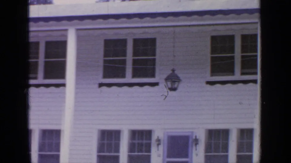Greenwood Lake residential exterior showing white siding, multi-paned windows, a porch lamp, columns, and a front door.