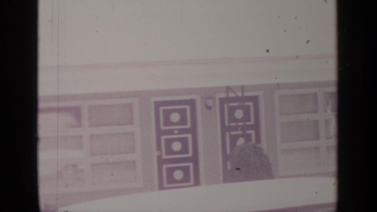 Snow-covered building facade with windows and dark geometric door panels.
