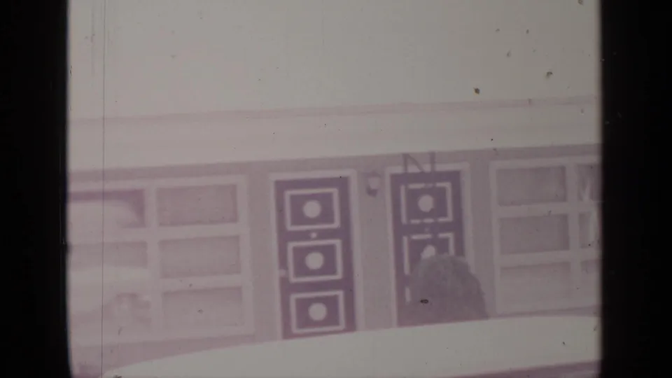 1964 Greenwood Lake exterior showing a snowbank, broad windows, and dark geometric door panels on a winter building facade.