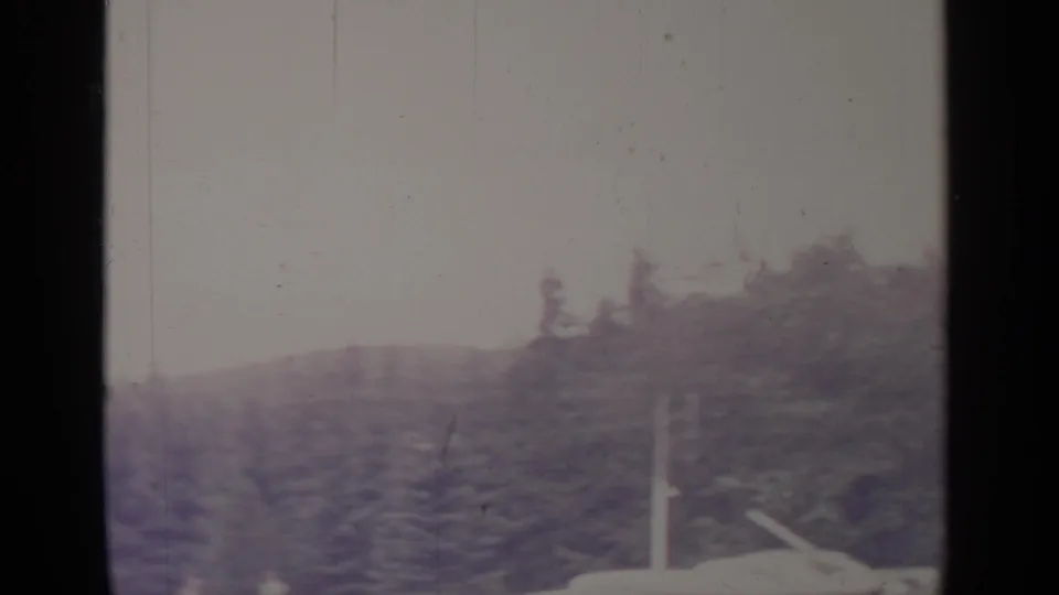 Greenwood Lake winter view with wooded shoreline, overcast sky, snow-bright ground, and dark 8mm frame borders.