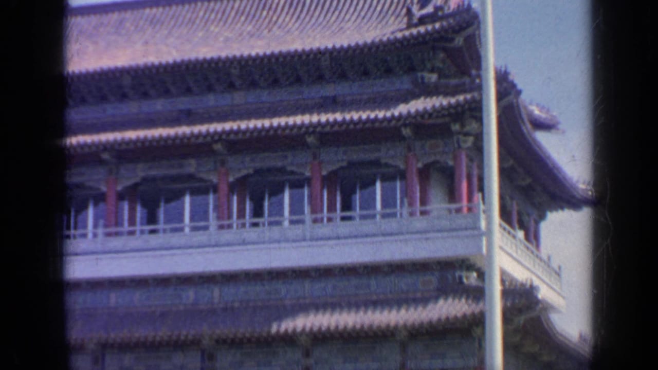 Chinese-style pavilion corner at the 1964 Flushing Meadows fair site, framed through 8mm film with a vertical pole crossing the view.