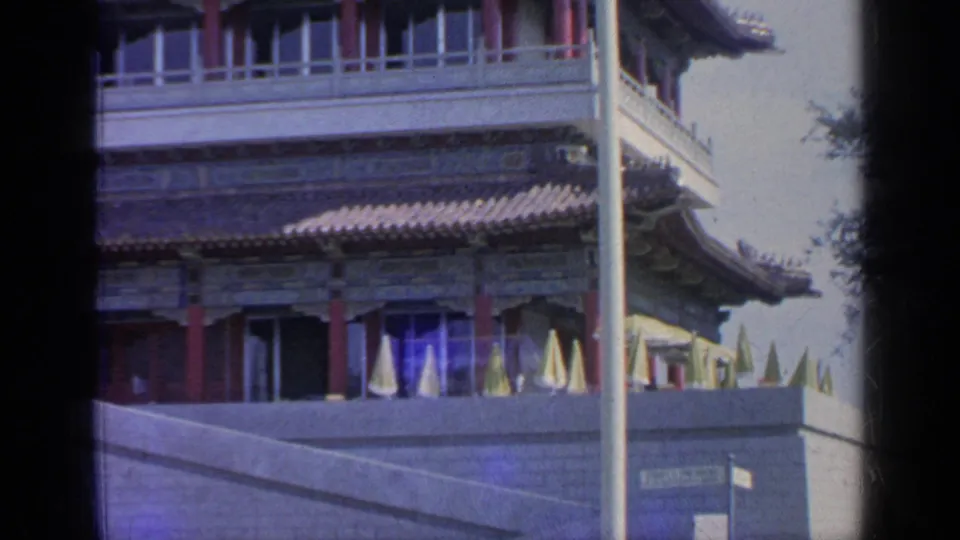 Chinese-style pavilion at the 1964 Flushing Meadows fair site, showing terrace umbrellas below decorated eaves and a foreground pole.