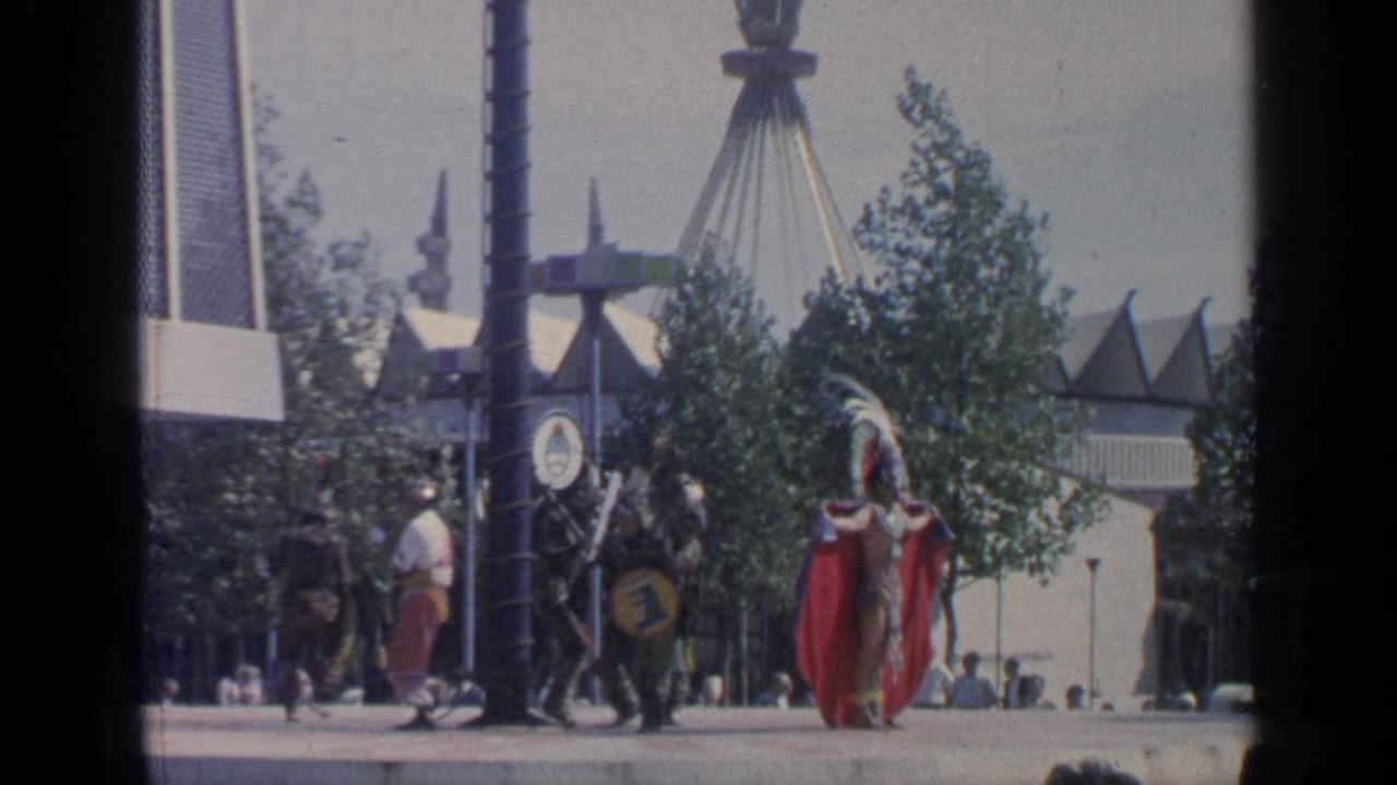 Costumed figure and fairgoers near a pavilion area at the World's Fair.