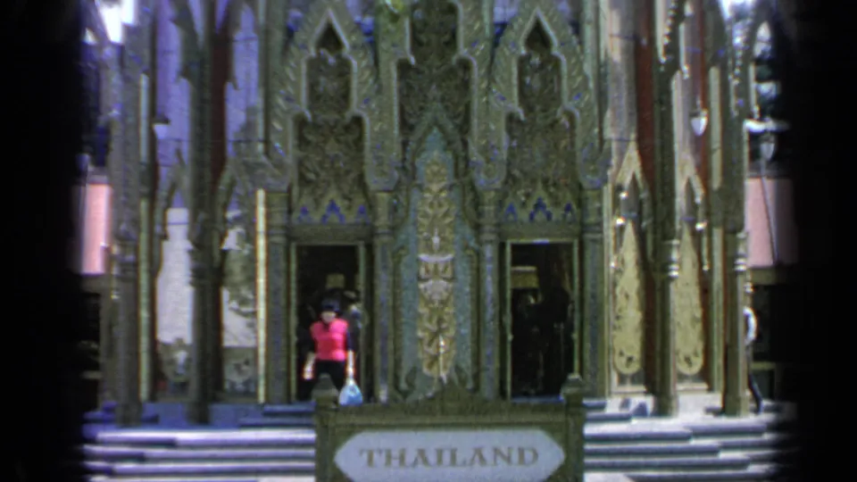 Closer 1964 World's Fair view of the Thailand Pavilion facade, with carved ornament, open doorways, steps, and visitors entering or leaving.