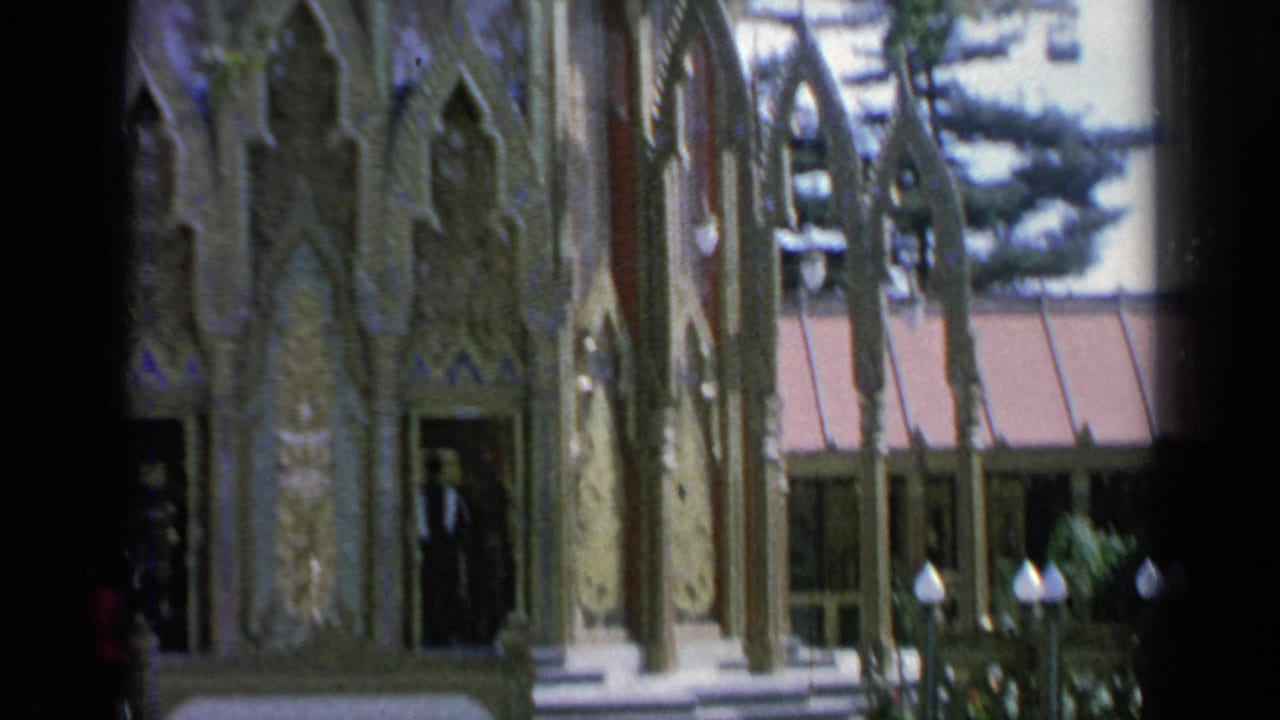 Closer view of ornate pavilion wall and arched doorway with people near the entrance.