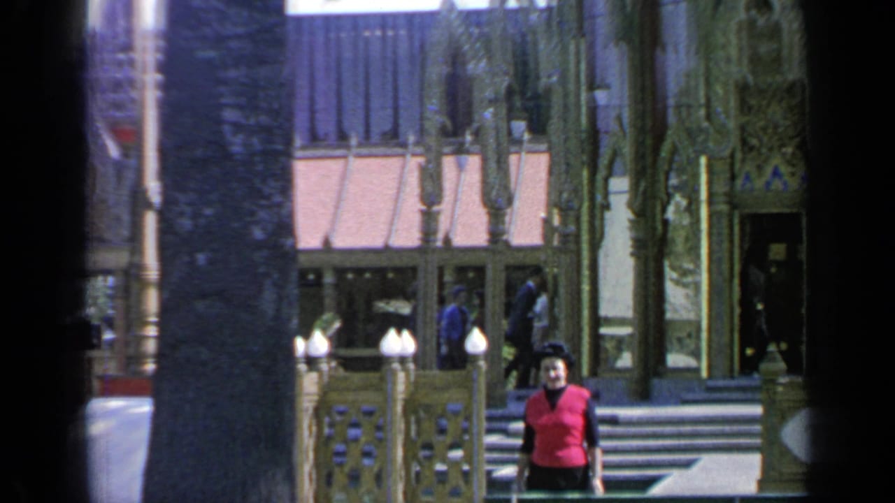 Thailand Pavilion entrance partly blocked by a dark vertical frame edge, with a woman at right.