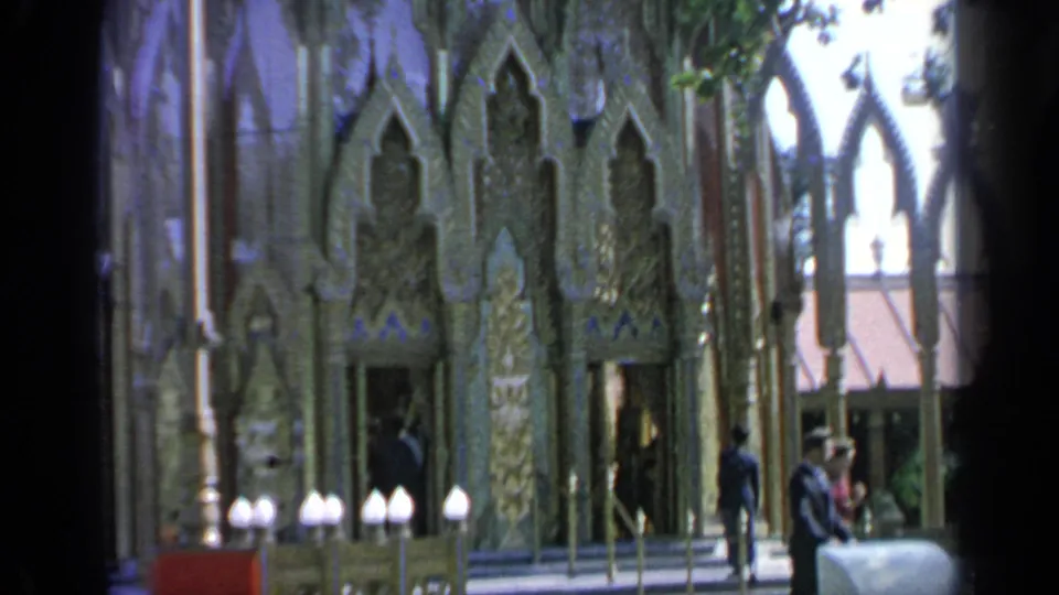 1964 Flushing Meadows World's Fair view of the Thai pavilion entrance with carved gold ornament and visitors approaching.