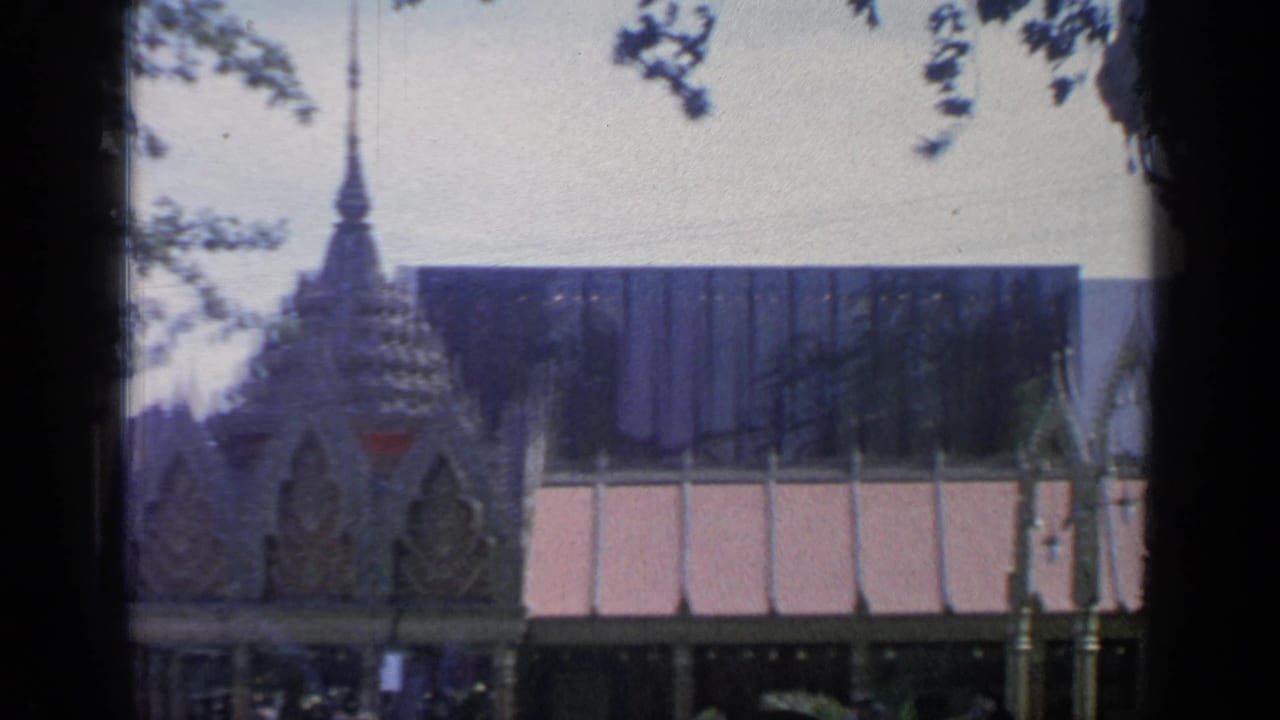 Nearby exhibition building seen past trees and pavilion roofline.
