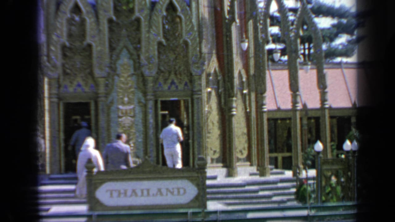 People approach the pavilion entrance beside a foreground THAILAND sign.