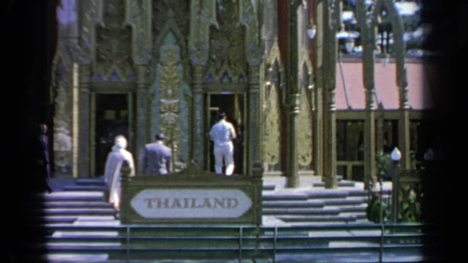 Fair visitors pass the THAILAND sign while heading up the steps to the ornate pavilion facade in Flushing Meadows.