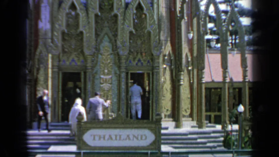 A wider 8mm frame shows visitors near the THAILAND sign, steps, and decorated pavilion entrance at the 1964 World's Fair.