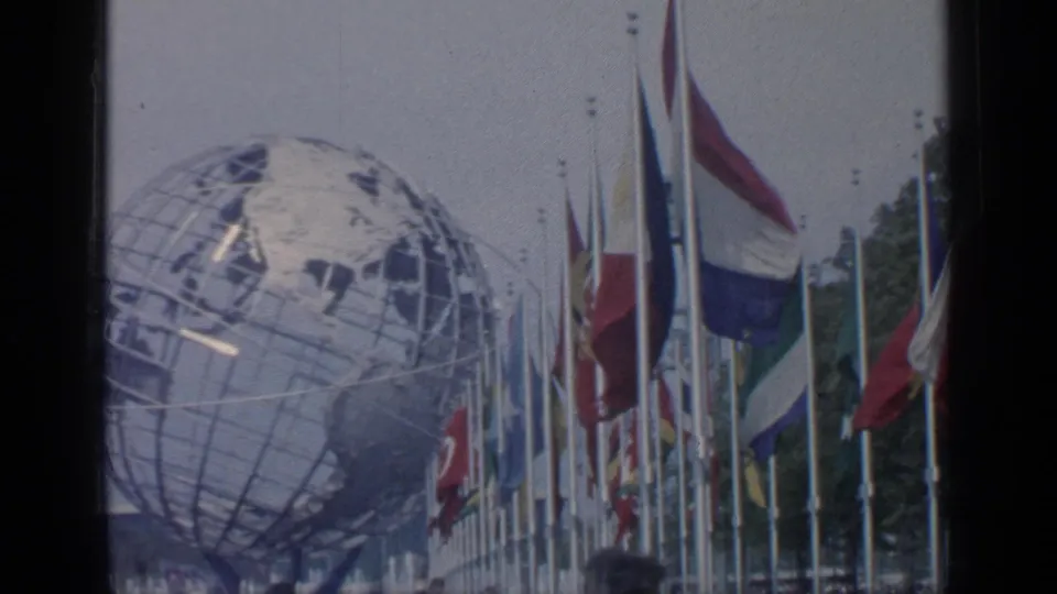 The Unisphere appears behind rows of international flags at the 1964 New York World's Fair site.