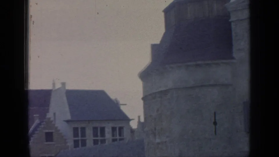 Soft 8mm view of Belgian Village stonework and gabled architecture at Flushing Meadows, partially blocked by window framing.