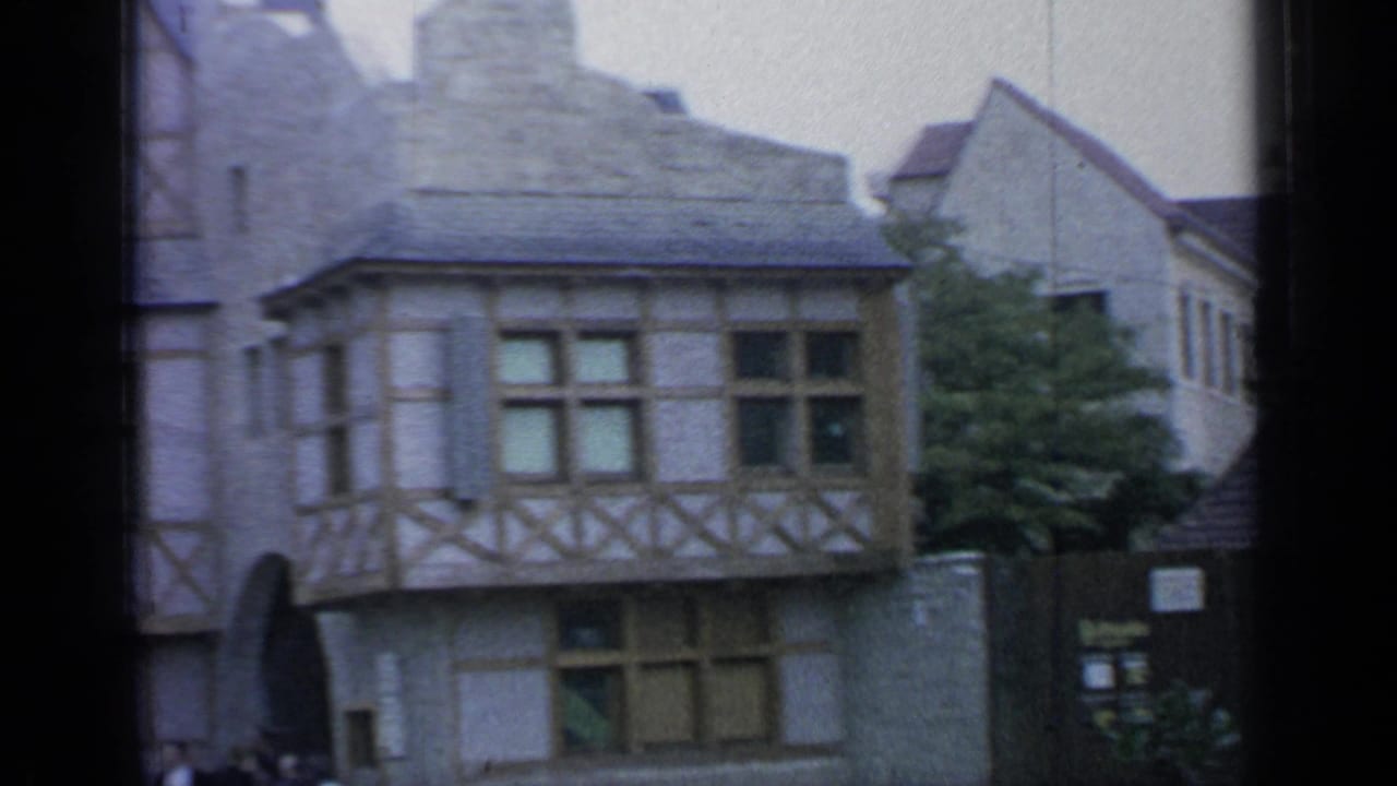 Belgian-style facades with stone walls, half-timbered upper floors, and a yellow waffle sign.