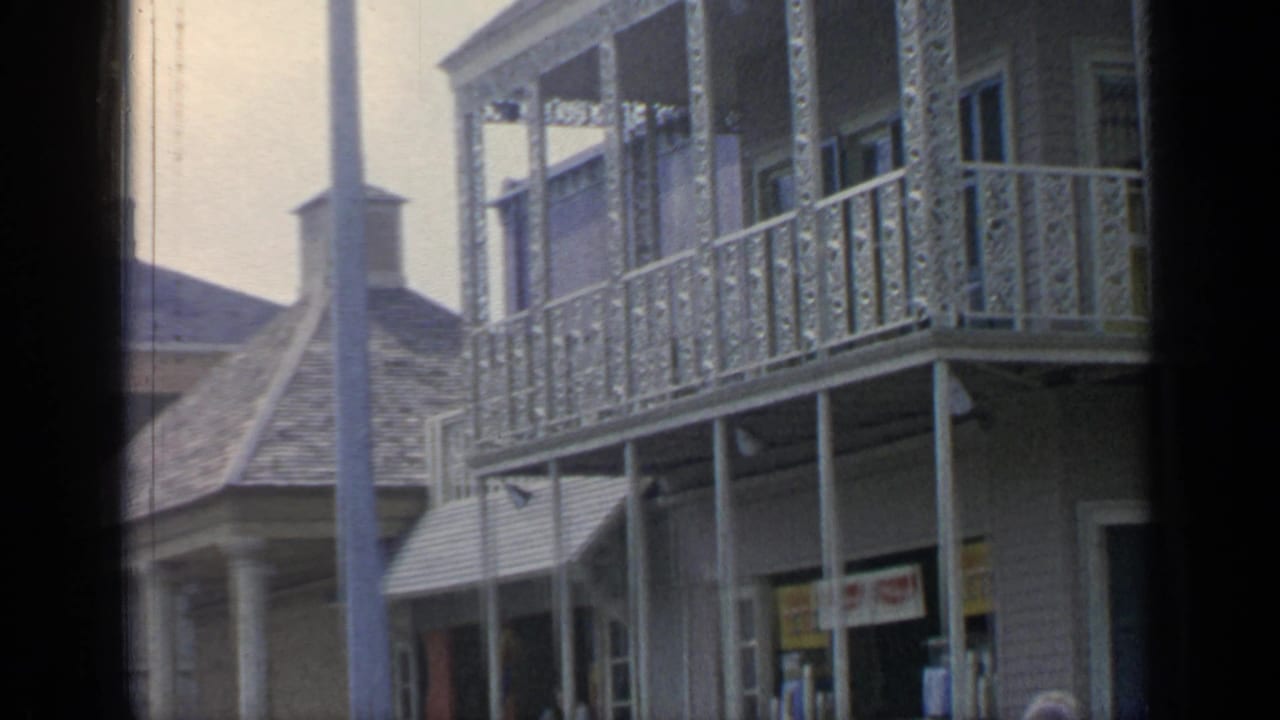 Decorative balcony and shopfront facade with peaked roofs and tall posts.