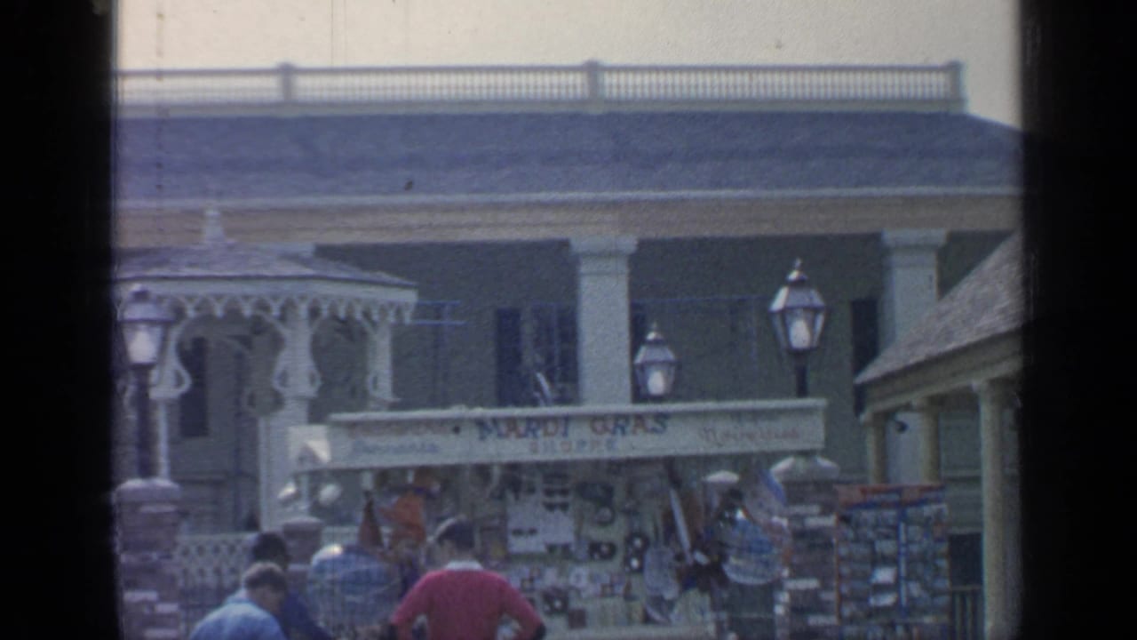 Souvenir stall below a columned building with gazebo trim and tourists in the foreground.