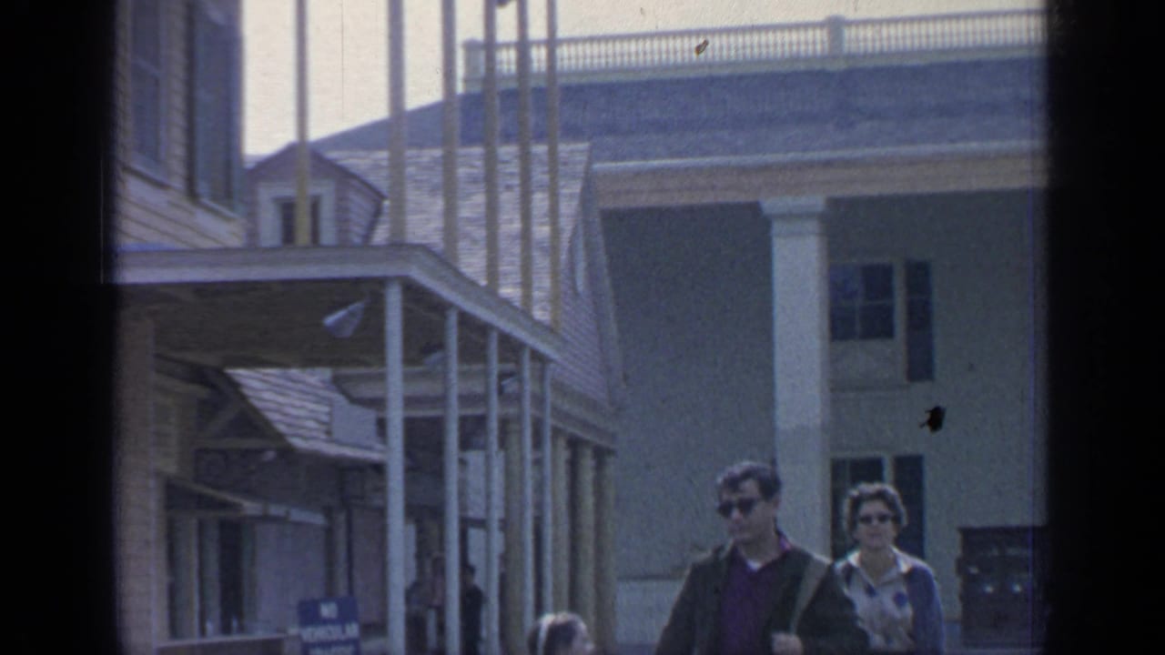 Visitors in sunglasses walk past a porch-like exhibition structure at Flushing Meadows in 1964.