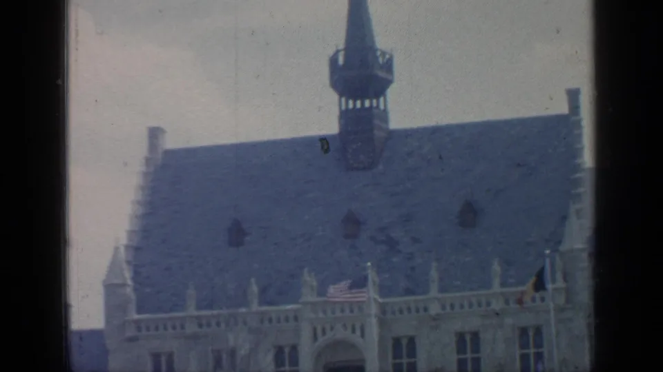 1964 Flushing Meadows footage showing the upper roofline and spire of a European-style stone building.