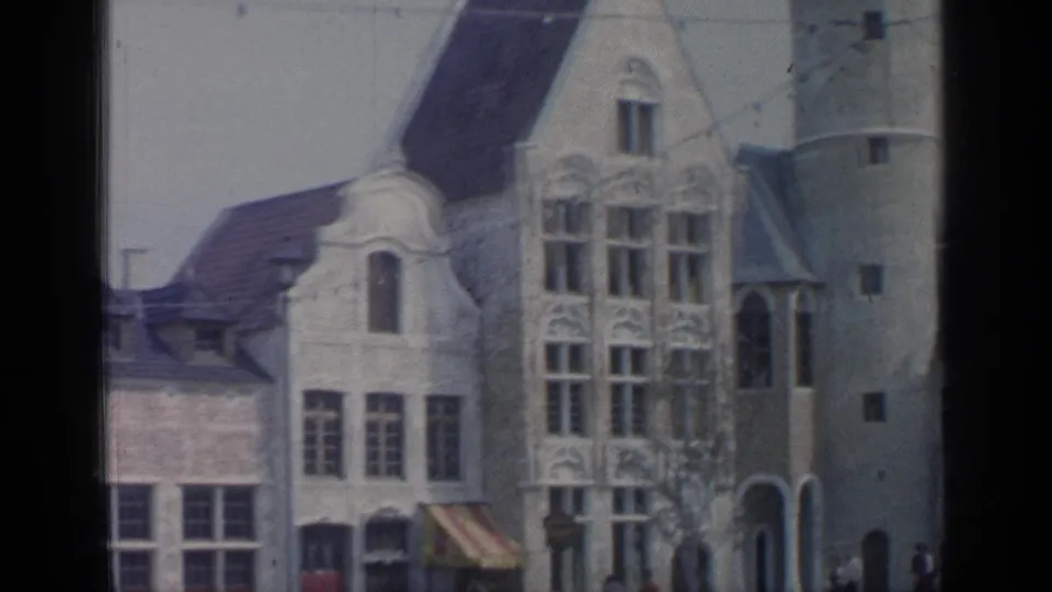 European-style building frontage at Flushing Meadows with decorative windows, a striped awning, and a rounded tower.