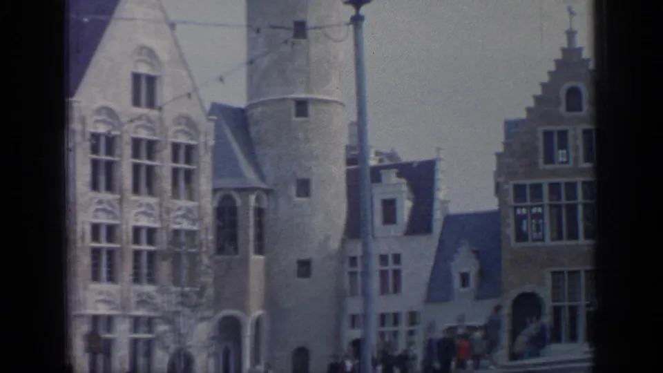 1964 Flushing Meadows view of a round tower between ornate facades and a stepped-gable building, with visitors in the distance.