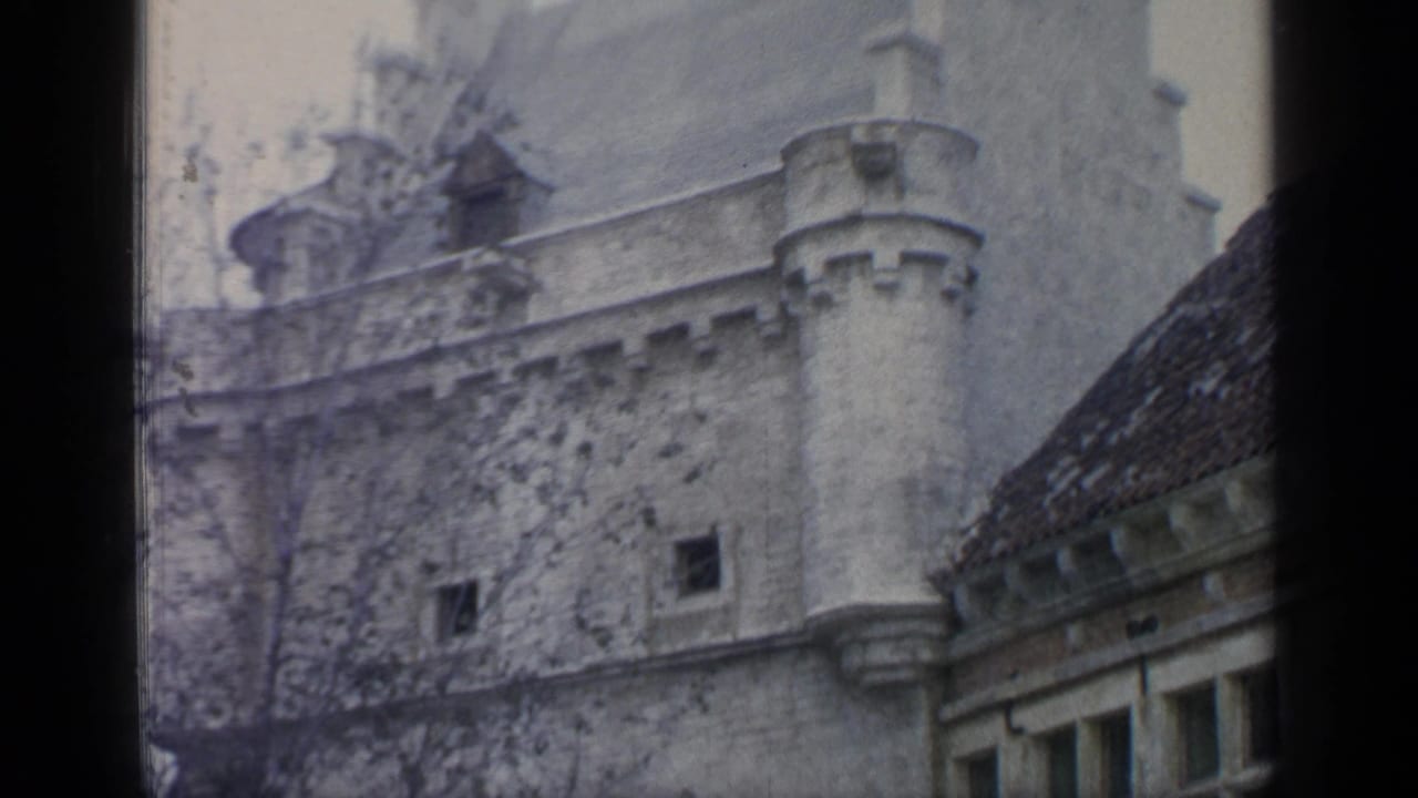 Stone turret wall and roofline beside a dark film-frame divider.