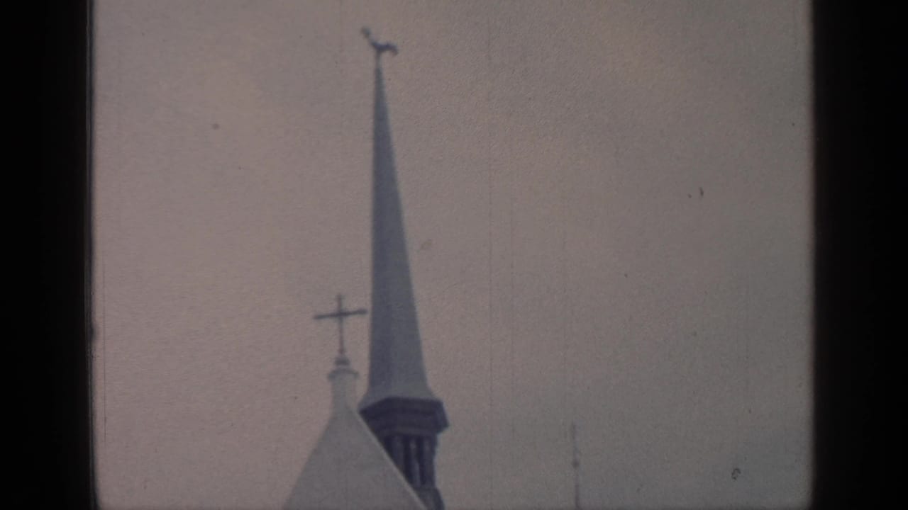 Church steeple with crosses against a muted sky.