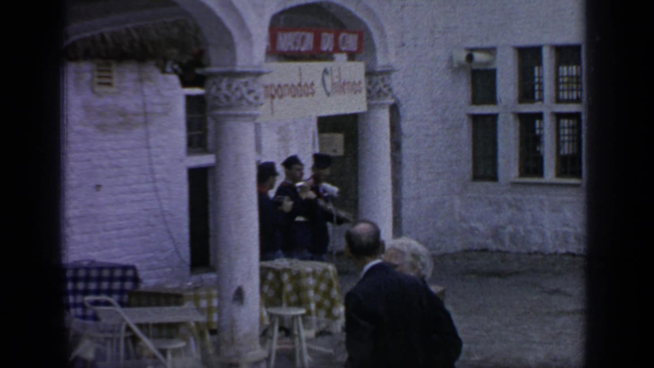 People gathered near an arched building with an Oriental Fudge sign.