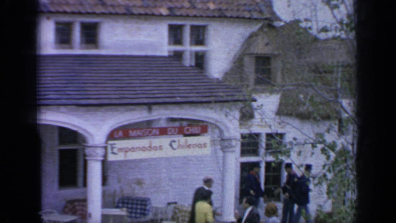 A white building with La Maison du Chili signage stands behind passing fairgoers.
