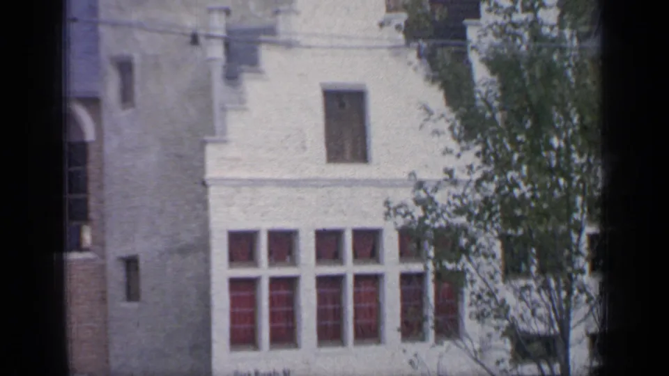 1964 Flushing Meadows view of a pale urban building with red-tinted windows, tree branches and dark contact-sheet framing.
