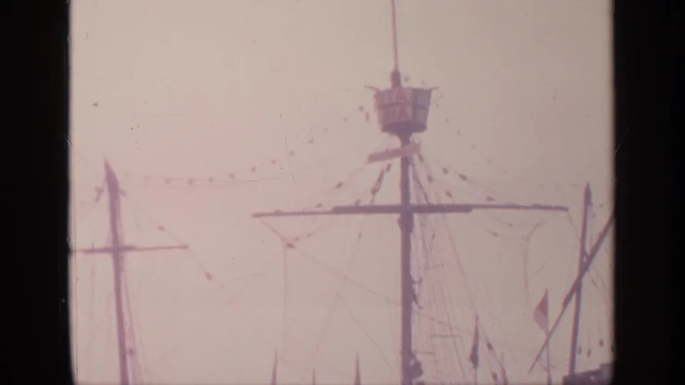 1964 Flushing Meadows fair footage showing a Santa Maria ship replica mast, rigging, small flags, and hazy sky.