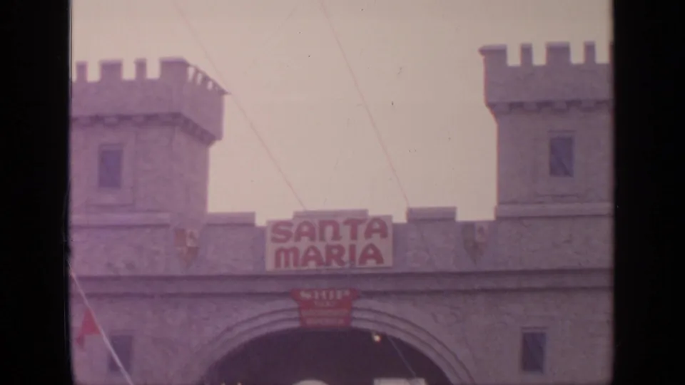 1964 Flushing Meadows view of the Santa Maria attraction entrance, with crenellated towers, archway, sign, and faint visitors.
