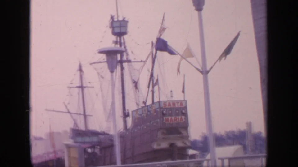A replica Santa Maria sailing ship attraction at the 1964 New York World's Fair, with masts, flags, and nearby fair structures.