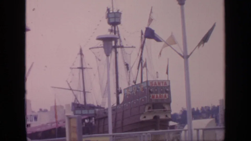 1964 Flushing Meadows footage of the Santa Maria replica ship attraction, with flags, masts, signage, and fairground architecture visible.
