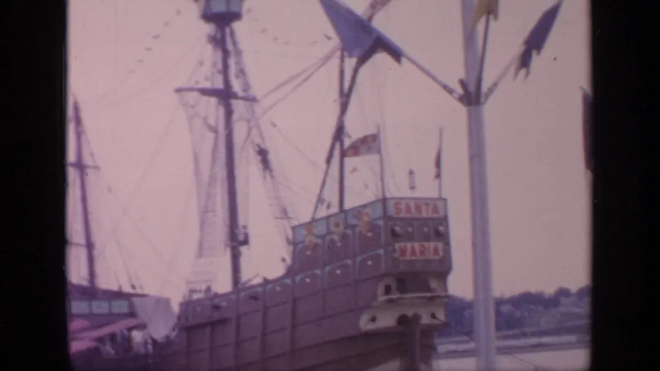 1964 Flushing Meadows view of the Santa Maria replica ship, with stern lettering and tall rigging visible in soft 8mm footage.