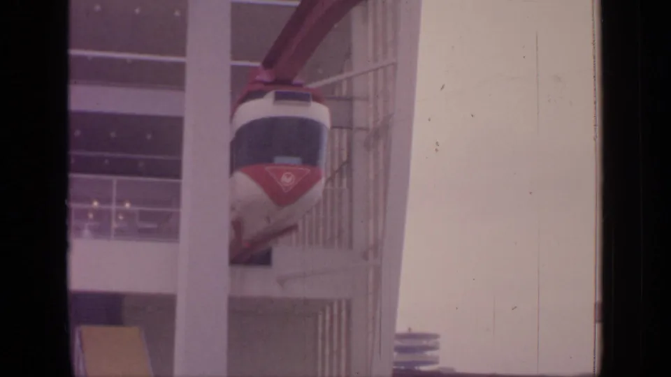 Late frame of the 1964 Flushing Meadows monorail entering the station, with its front emblem faintly visible.