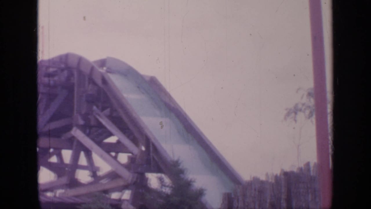 Roller coaster structure and track seen through a faded 8mm frame.