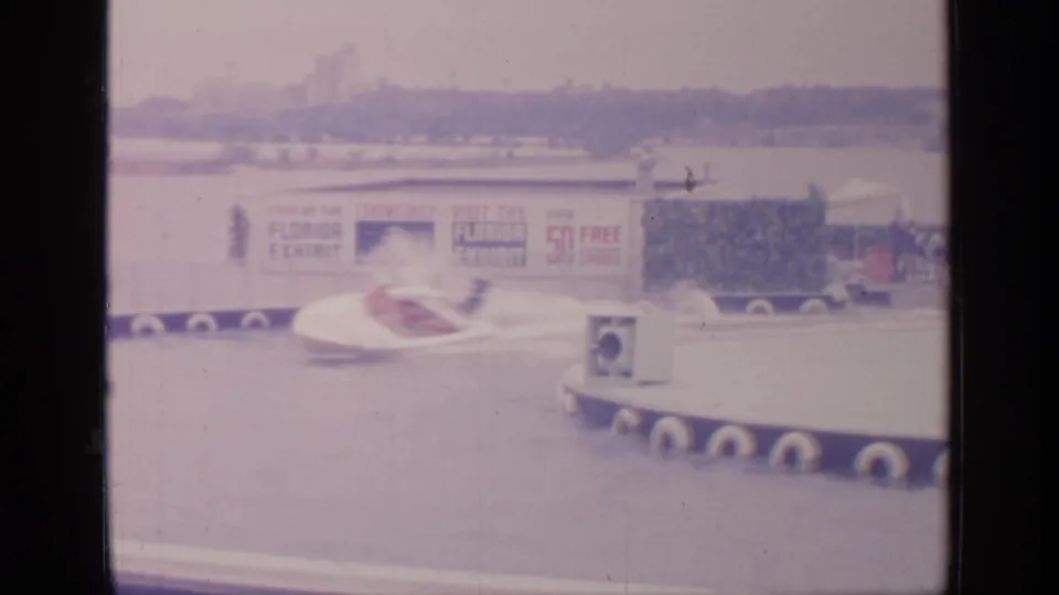 A white speedboat with occupants moves along the 1964 Flushing Meadows water course beside a platform and Florida Exhibit sign.