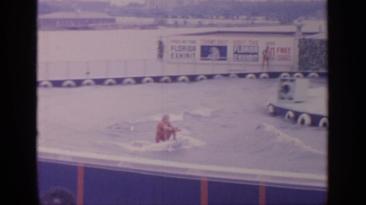 Water-ski performer in red moving across a pool with Florida Exhibit signage behind him.