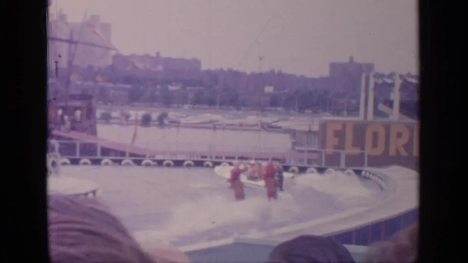 Two red-costumed waterskiers perform beside a FLORIDA sign during the 1964 Flushing Meadows fair water show.