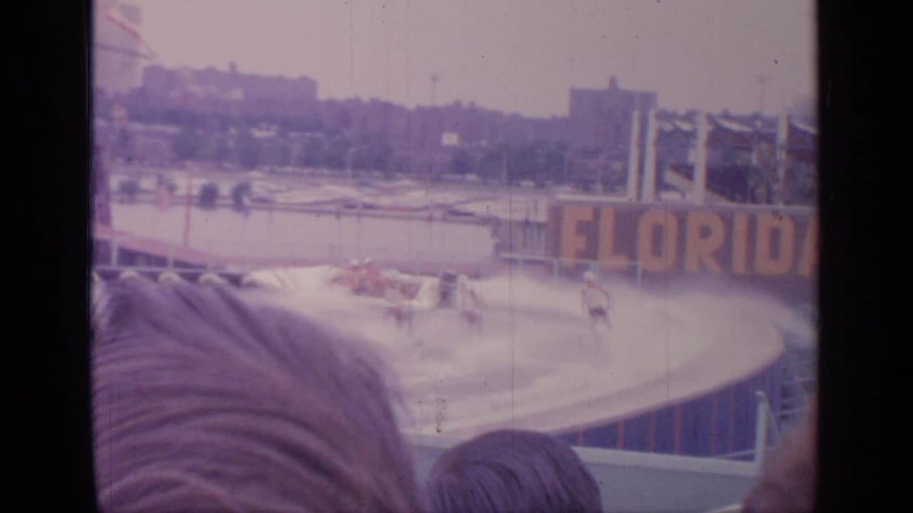 Florida sign behind a circular water-ski pool with spectators in front.