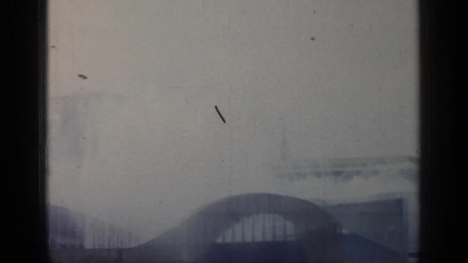 The final 8mm frame shows a blurred ramp and pale fairground forms as the boat or camera moves past.