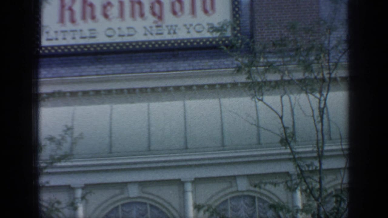 Rheingold sign above arched windows with trees in the foreground.