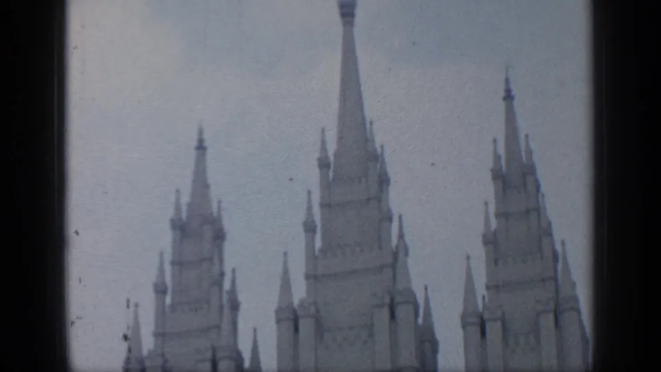 Low-angle 1964 Flushing Meadows frame with three spired tower tops, soft focus, and visible film texture.