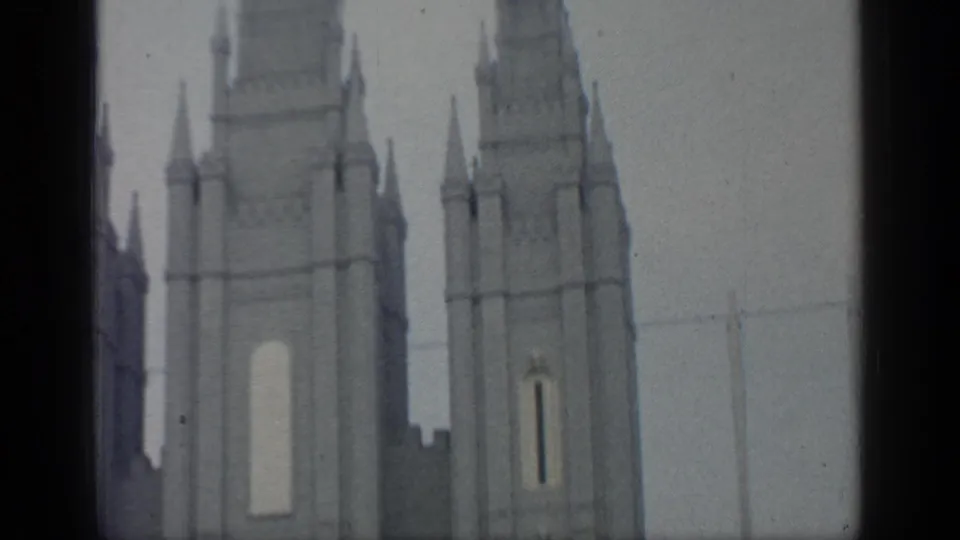 Close 8mm view of pale World's Fair tower architecture at Flushing Meadows, with narrow openings and soft focus.