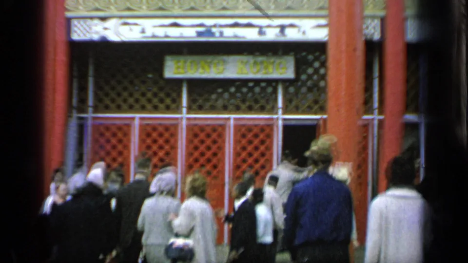 A Hong Kong sign appears above visitors entering or passing the pavilion area at Flushing Meadows in 1964.