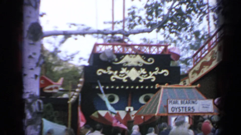 1964 Flushing Meadows World's Fair crowd near a Pearl Bearing Oysters sign beneath red, black, and gold boat-like decor.