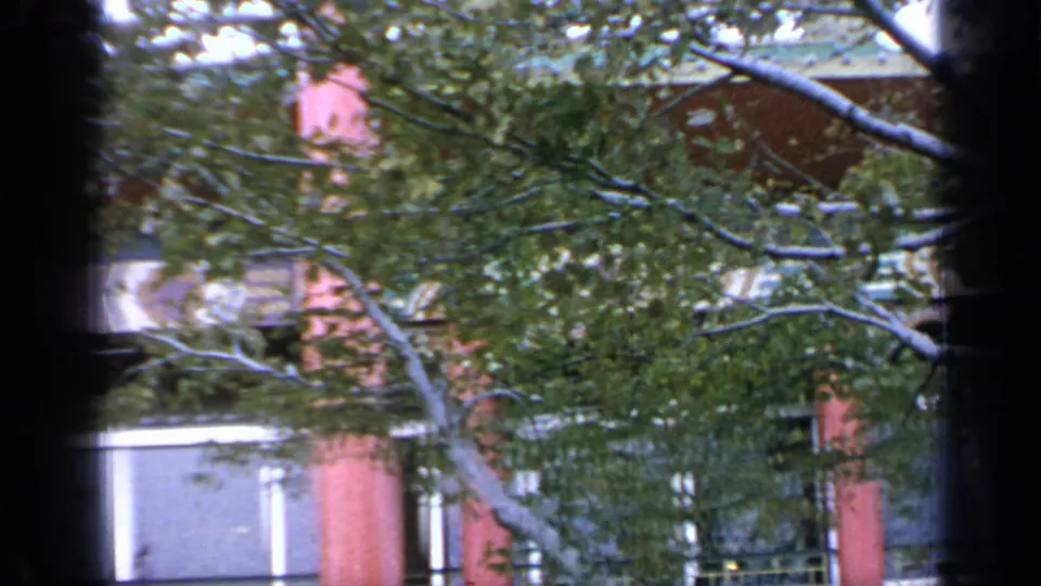 1964 Flushing Meadows fair architecture with red columns, colorful eaves, windows, and trees in a soft 8mm frame.