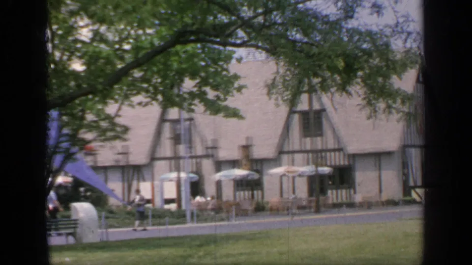 A closer 1964 fairground view shows the Tudor-style building behind umbrellas as a visitor walks along the path.