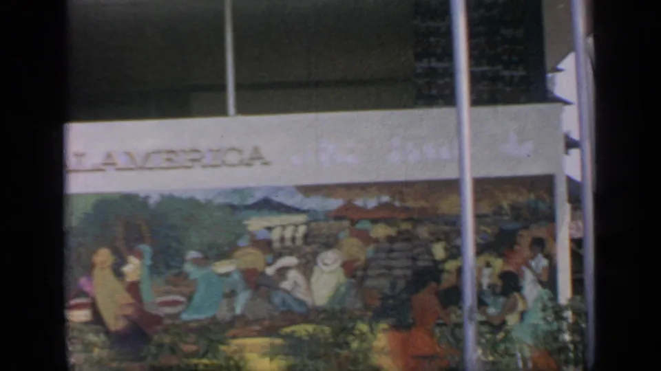 1964 Flushing Meadows view of a colorful mural or sign panel with partial PALAMERICA lettering, greenery, and vertical poles.